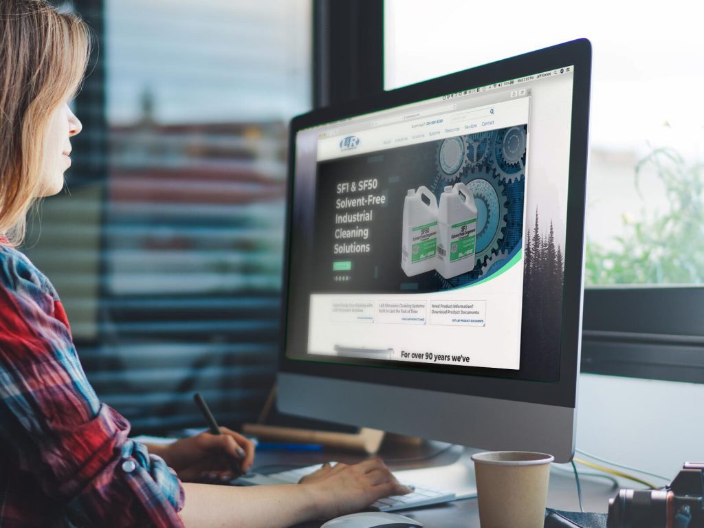 Woman on desktop computer browsing products on the L&R Ultrasonics website.