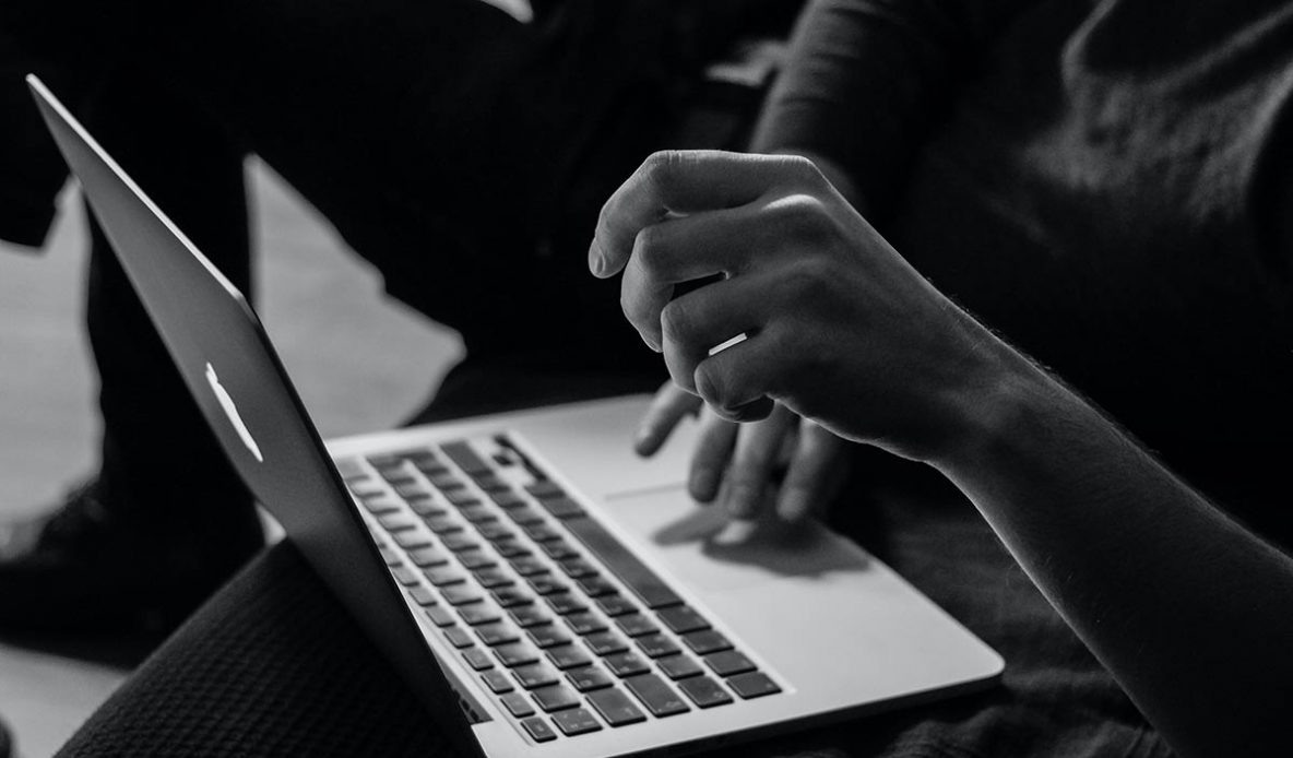 Hands scrolling on a laptop