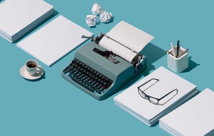 A retro-style typewriter arrainged between stacks of paper