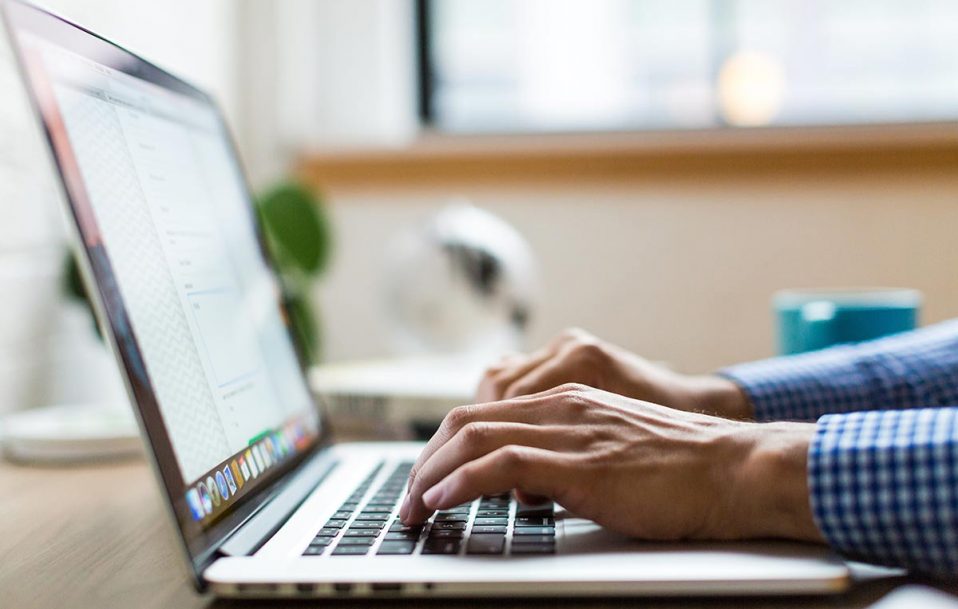 Writer typing on a laptop computer.