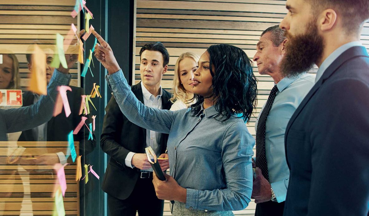 Co-workers looking at sticky notes and discussing ideas