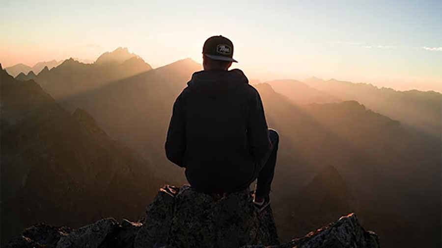 Someone sitting on a mountain peak