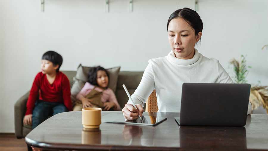 A mom working with kids in the background