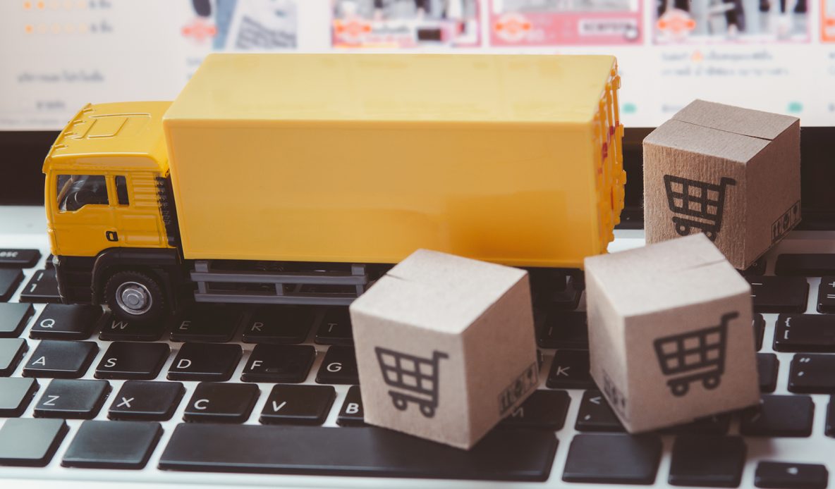 A mini truck dropping off packages on a computer keyboard