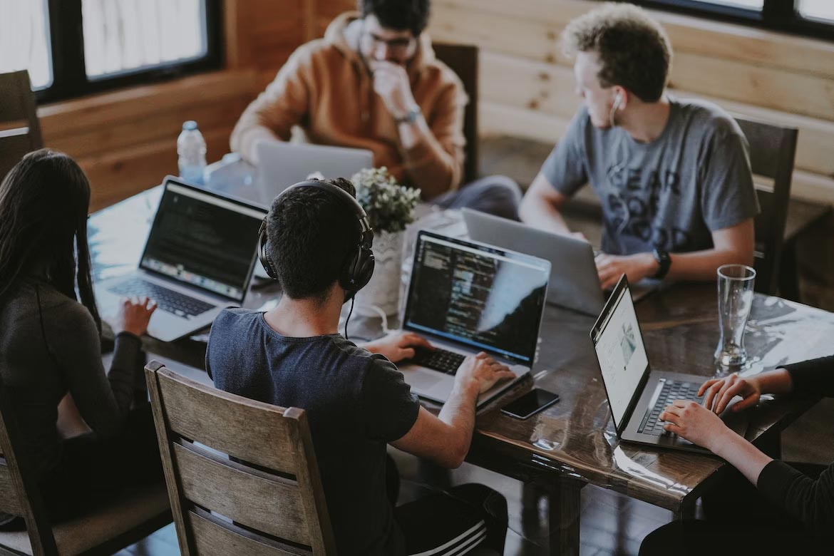 employees-talking-around-laptop-at -table